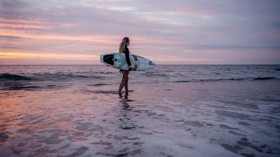 Fritid, Kvinde Med Surfbræt I Vandkanten I Solnedgang